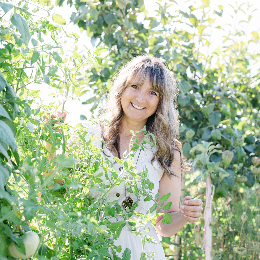 sanctuary_gardens_west_kelowna_kirsten_smiling_while_holding_plants